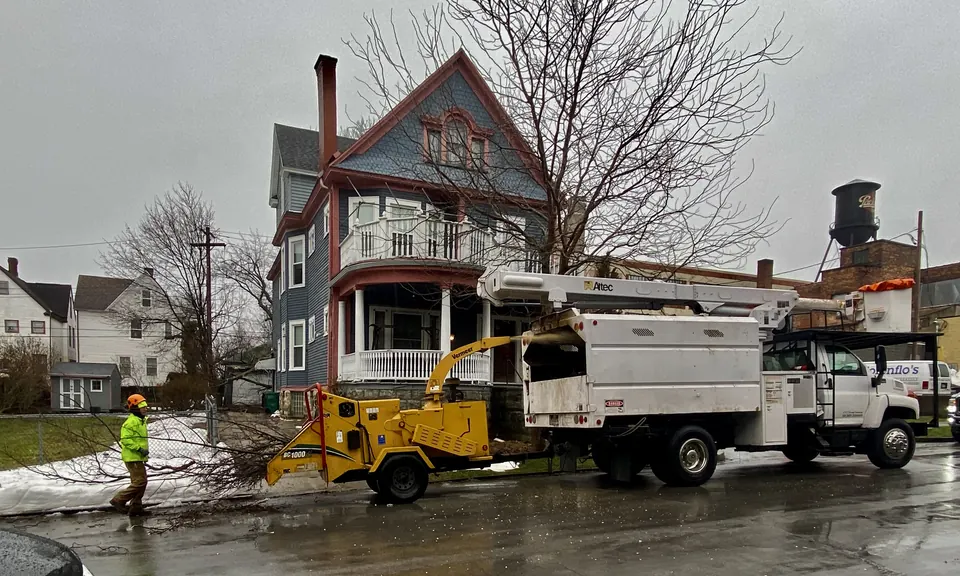 Crew feeding storm debris into a wood chipper